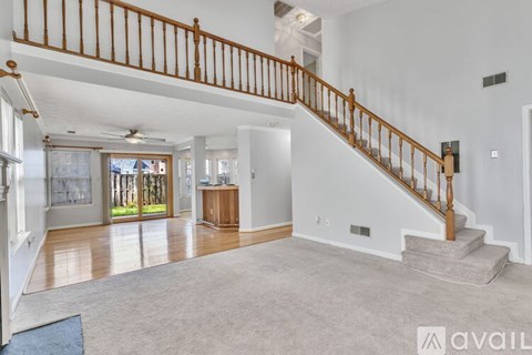 A spacious living room with a staircase leading to the upper floor.