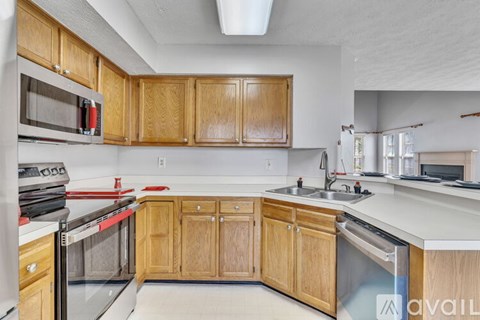 A kitchen with wooden cabinets and stainless steel appliances.