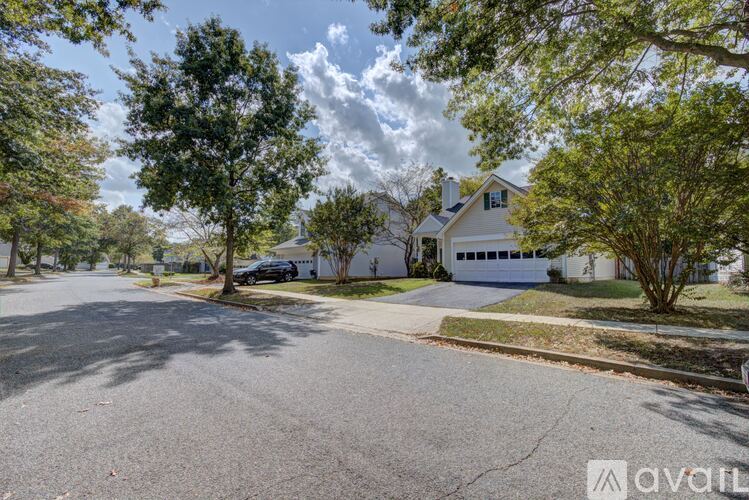 A house with a driveway and trees in front of it.