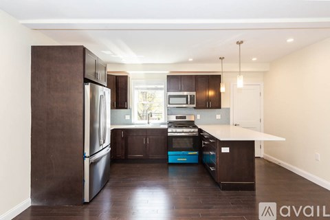 A kitchen with dark wood cabinets and stainless steel appliances.