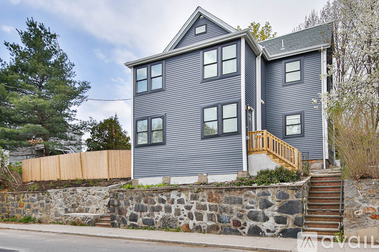 A house with a grey exterior and a wooden fence.