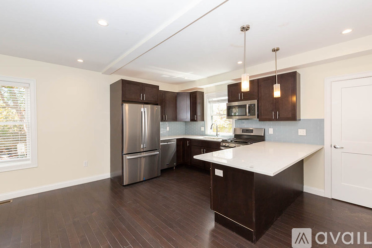 A kitchen with a refrigerator, microwave, and oven.
