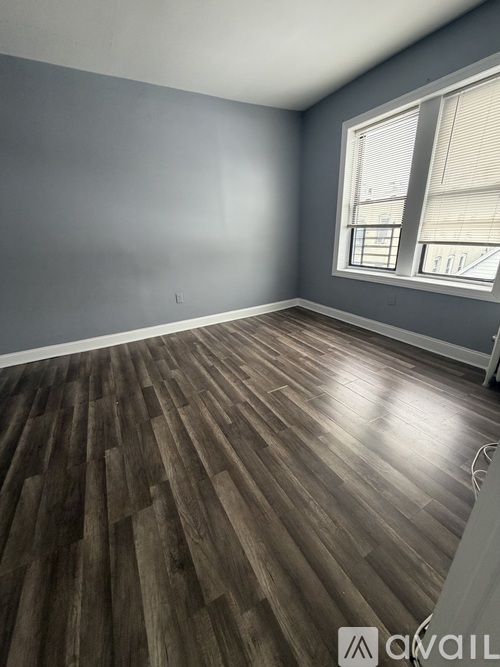 A room with wooden flooring and a window.