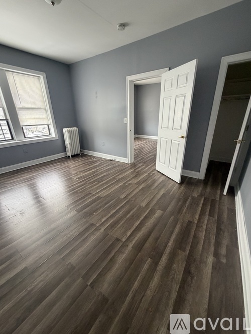 A room with wooden flooring and a white door.