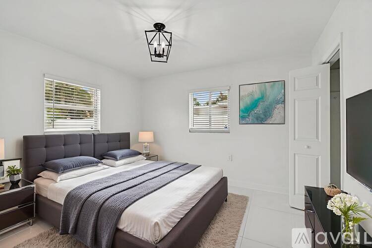 A bedroom with a large bed and a painting on the wall.
