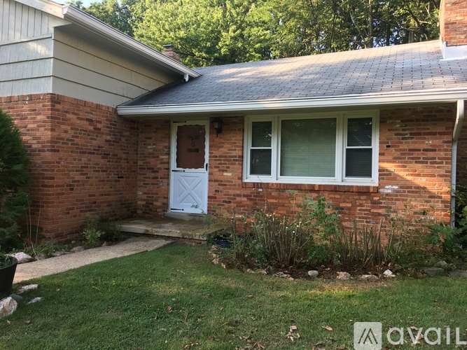 A house with a white door and a brick wall.