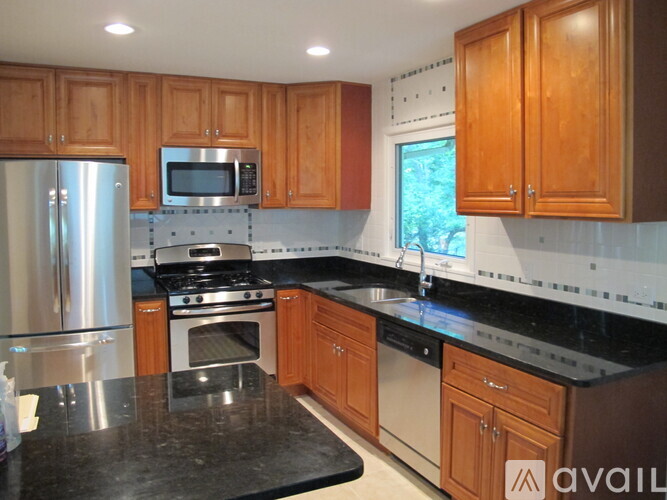 A kitchen with wooden cabinets and a black countertop.