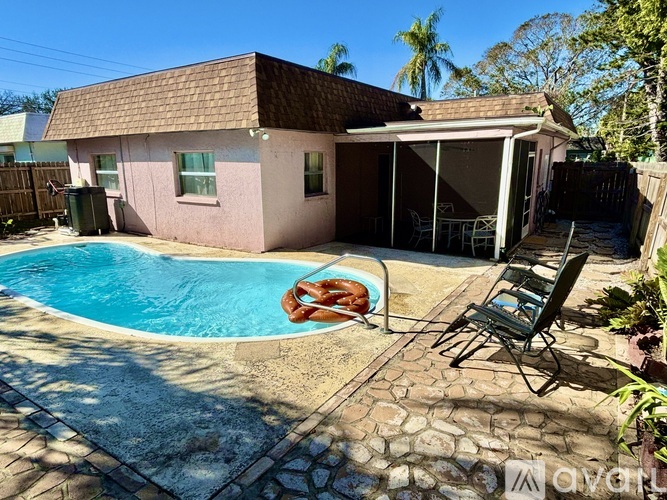 A small pink house with a pool in the backyard.
