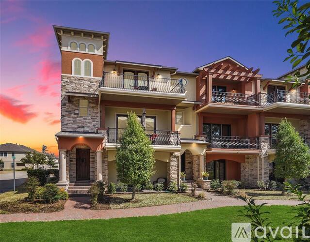 A large, multi-level home with a balcony and a front door.