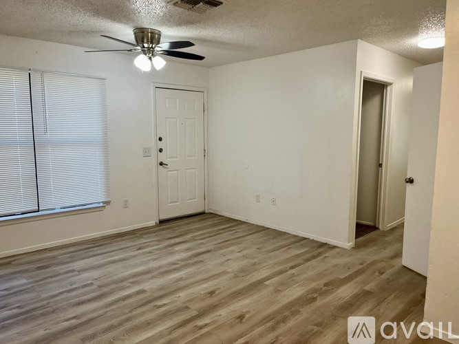 A room with a ceiling fan and two doors.