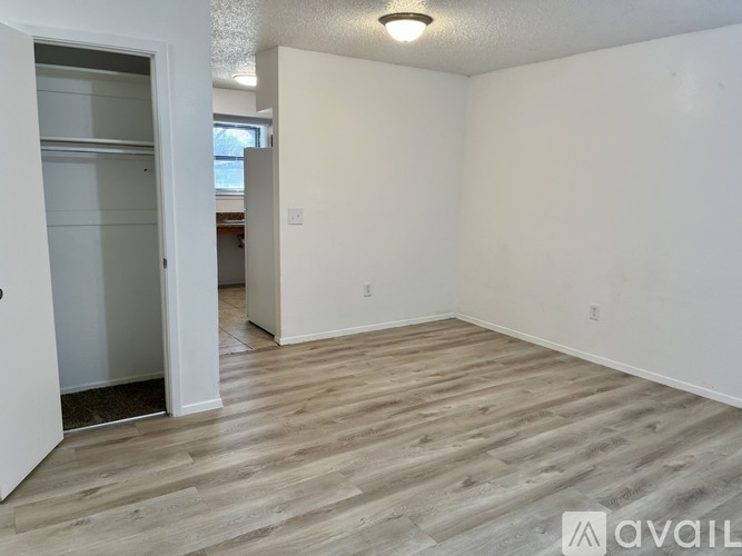 A room with wooden flooring and white walls is available for rent.