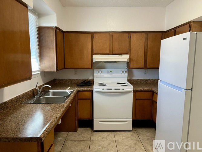 A kitchen with brown cabinets and a white stove top oven.