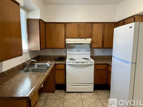 A kitchen with brown cabinets and a white stove top oven.
