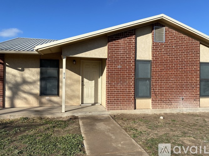 A brick house with a beige door and windows.