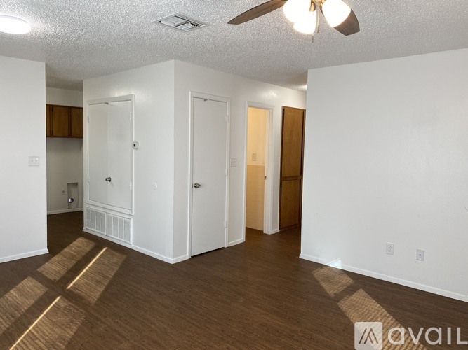 A room with a ceiling fan and wooden flooring.