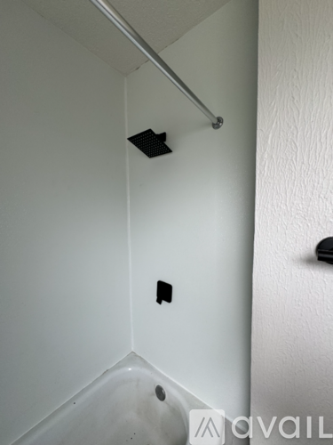 A white bathroom with a black vent and a black handle.