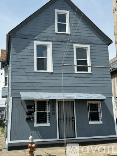 A grey house with a white door and windows.