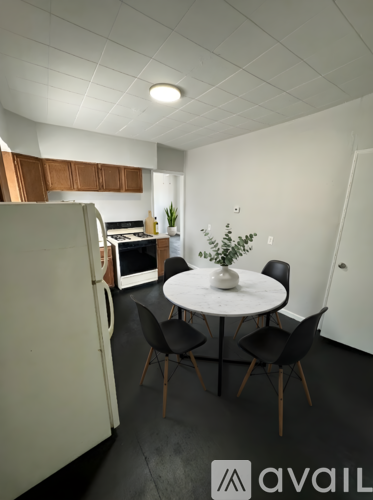 A kitchen with a table and chairs.