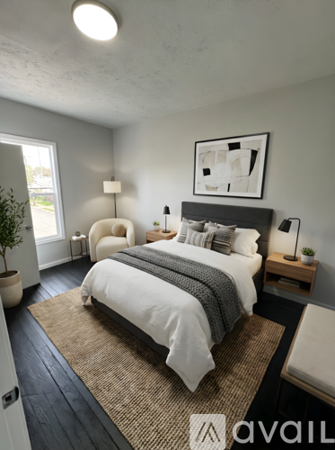 A bedroom with a large bed and a framed picture on the wall.
