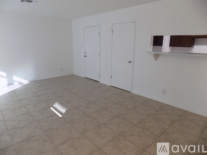 A spacious room with a tiled floor and a white ceiling.