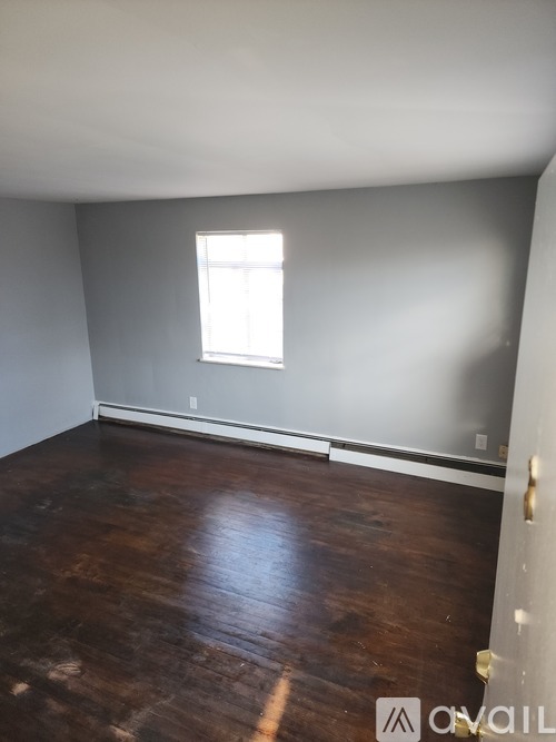 A room with a window and wooden floors.