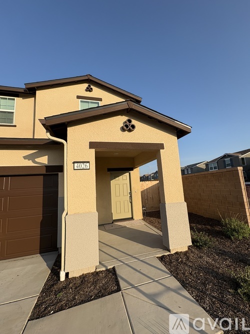 A beige house with a brown garage door and a stone archway entrance.