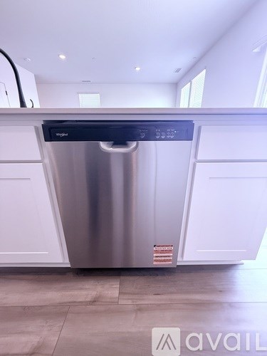 A stainless steel dishwasher is installed in a kitchen.