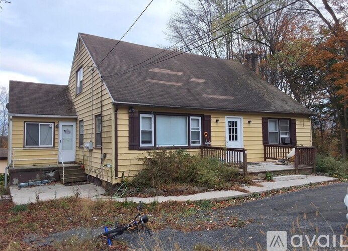 A small yellow house with a white door and windows.