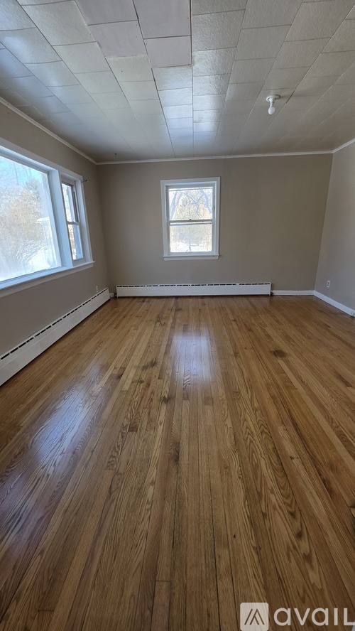 A room with wooden flooring and a window.