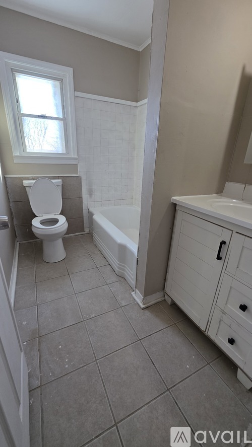 A bathroom with a toilet, sink, and bathtub.