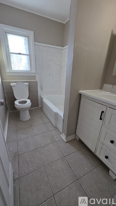 A bathroom with a toilet, sink, and bathtub.