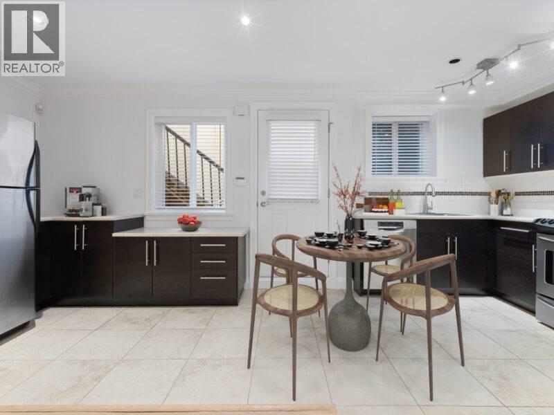 A modern kitchen with a dining table set for two.