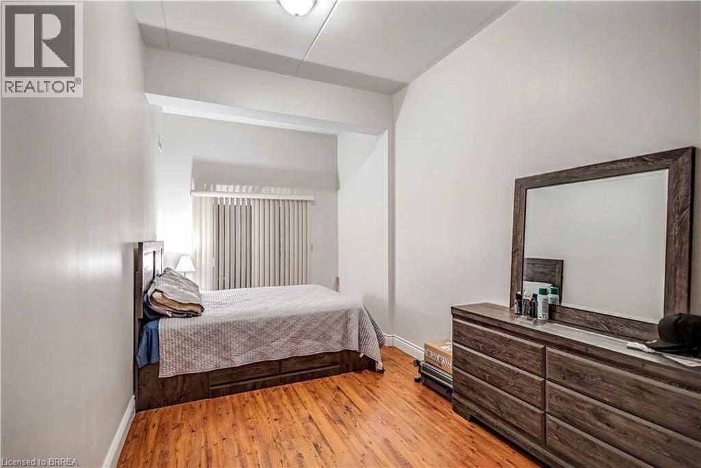 A bedroom with a bed, dresser, and mirror.