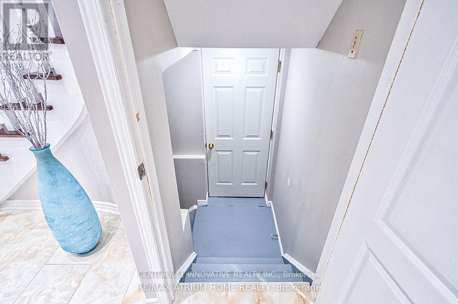 A hallway with a white door and a blue vase.