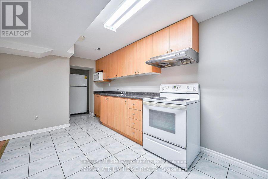 A kitchen with white appliances and wooden cabinets.