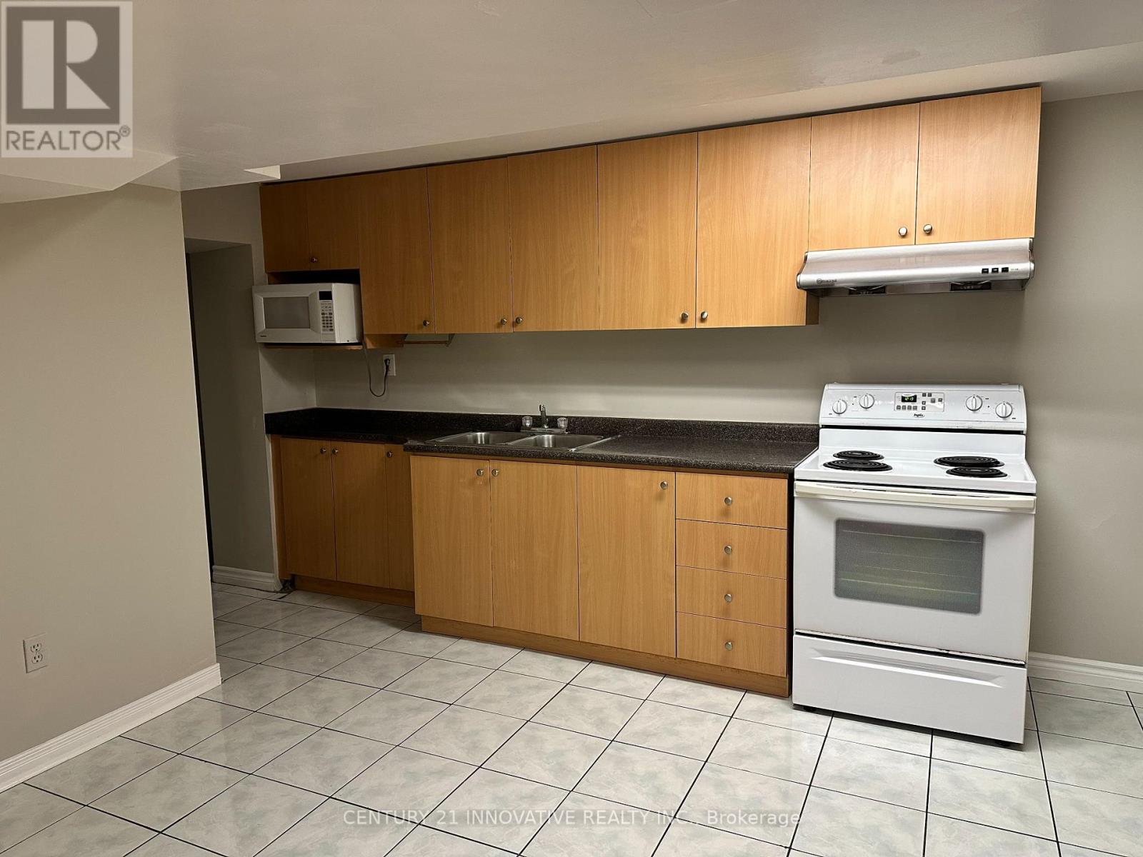 A kitchen with a white stove and wooden cabinets.