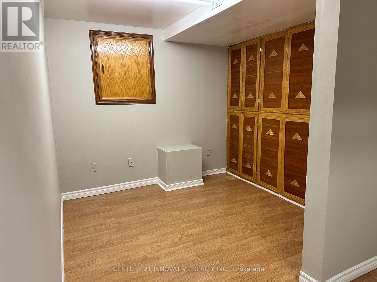 A room with wooden flooring and a wooden cabinet.
