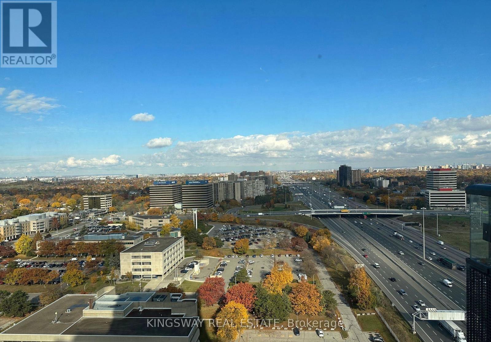 A view of a city from a high vantage point with a highway and buildings.