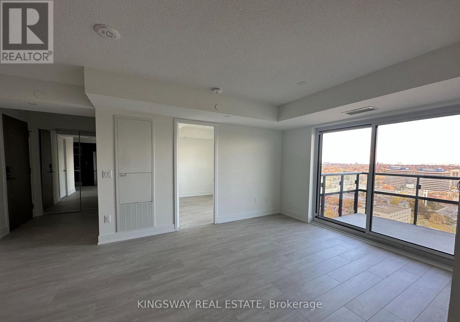 A spacious room with a view of the cityscape through the windows.