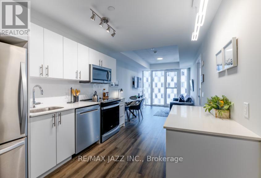 A modern kitchen with white cabinets and stainless steel appliances.