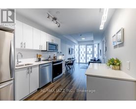 A modern kitchen with white cabinets and stainless steel appliances.