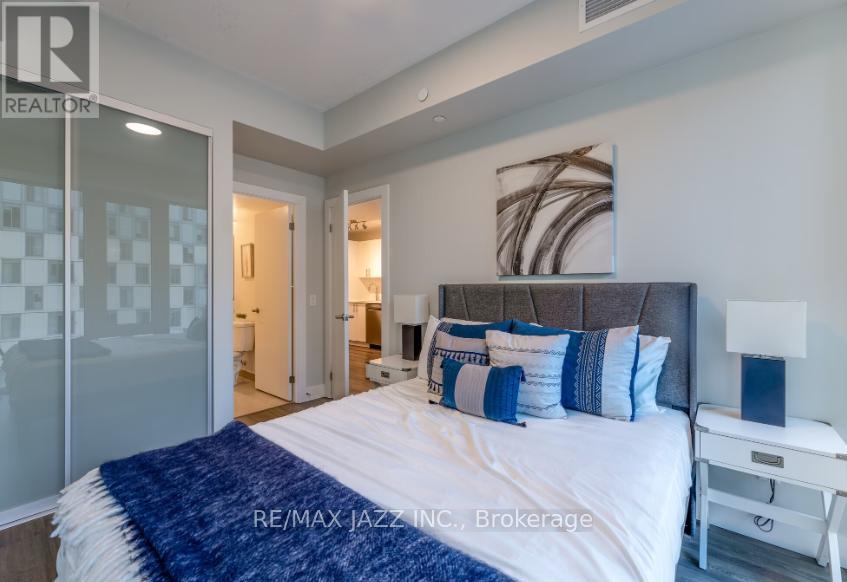 A bedroom with a bed, nightstand, and lamp.