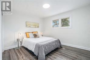 A bedroom with a bed, pillows, and pictures on the wall.