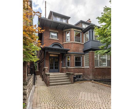 A large house with a black front door and a brick facade.