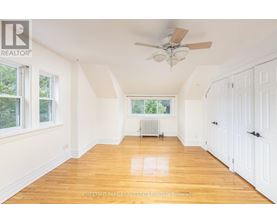 A room with a ceiling fan and wooden floors.