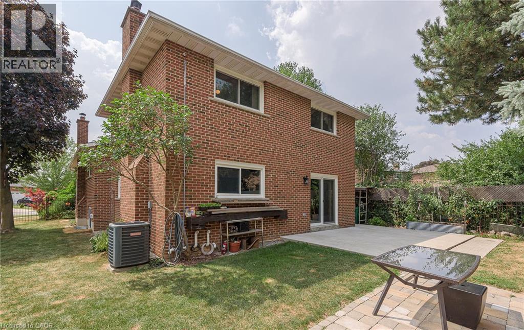 A house with a red brick exterior and a patio with a table and chairs.