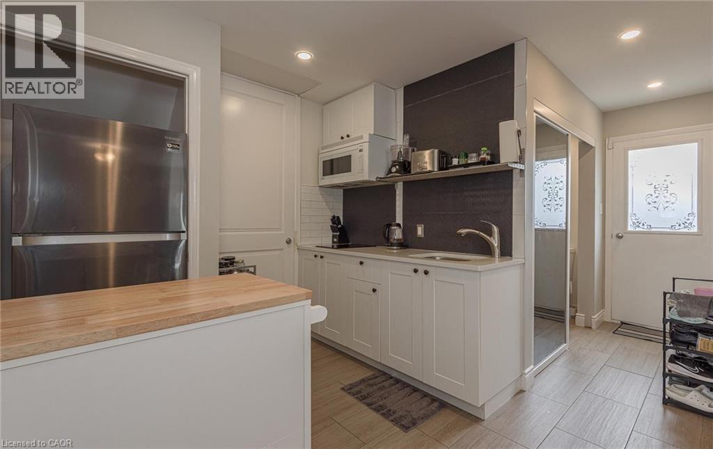 A modern kitchen with white cabinets and a wooden countertop.