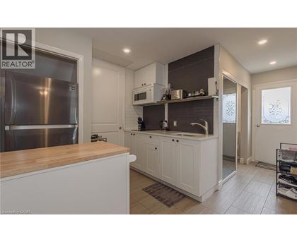A modern kitchen with white cabinets and a wooden countertop.
