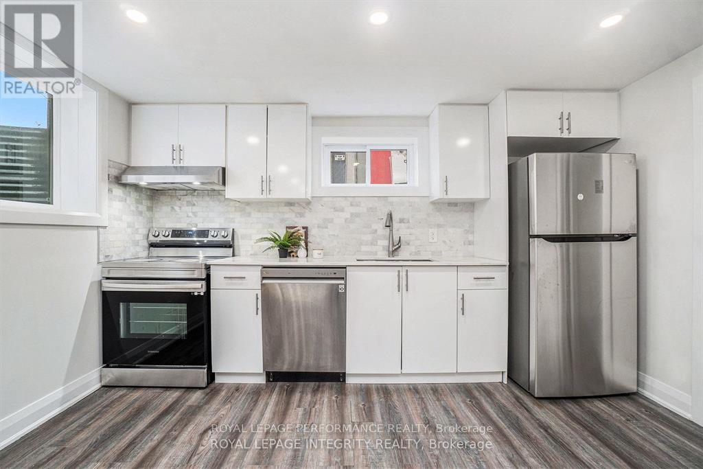 A modern kitchen with white cabinets and stainless steel appliances.