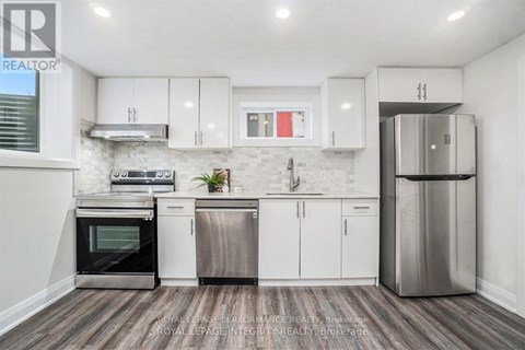 A modern kitchen with white cabinets and stainless steel appliances.